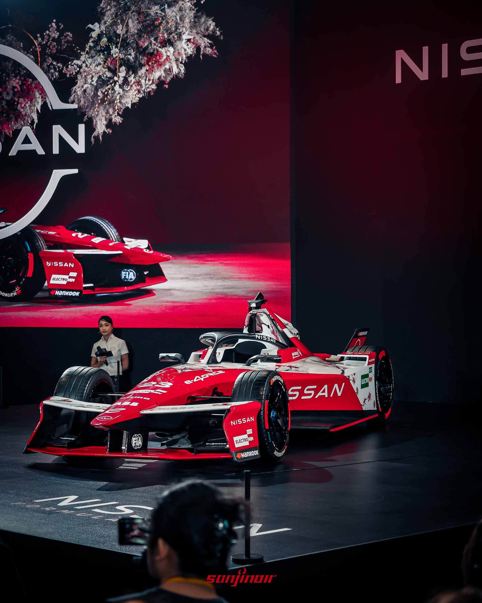 紅白色Nissan Formula E Gen3賽車展示於舞台上，背景有Nissan Logo與賽車影像。