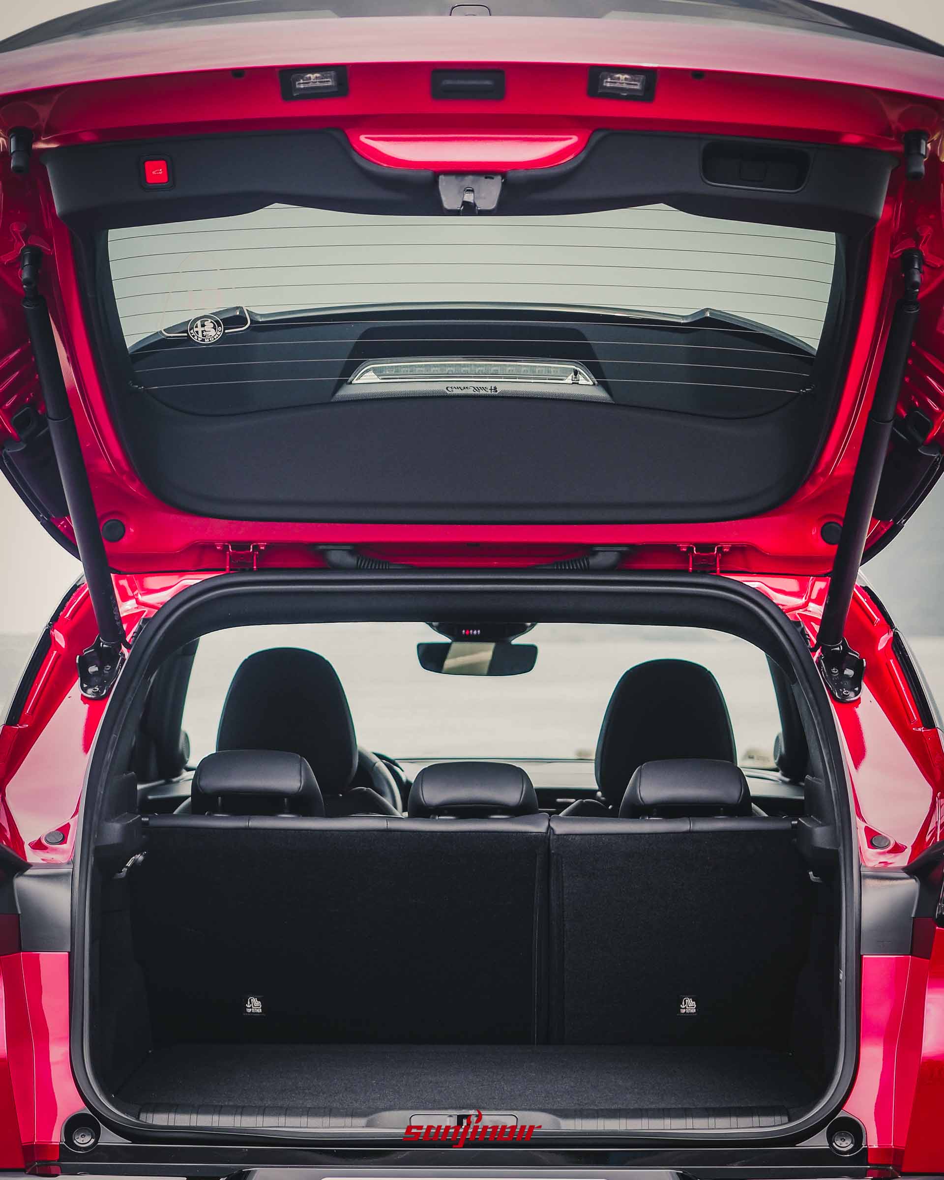 Alfa Romeo Junior打開後車廂的正後方視角,展示平整的行李廂空間、植絨材質與後座分離椅背。