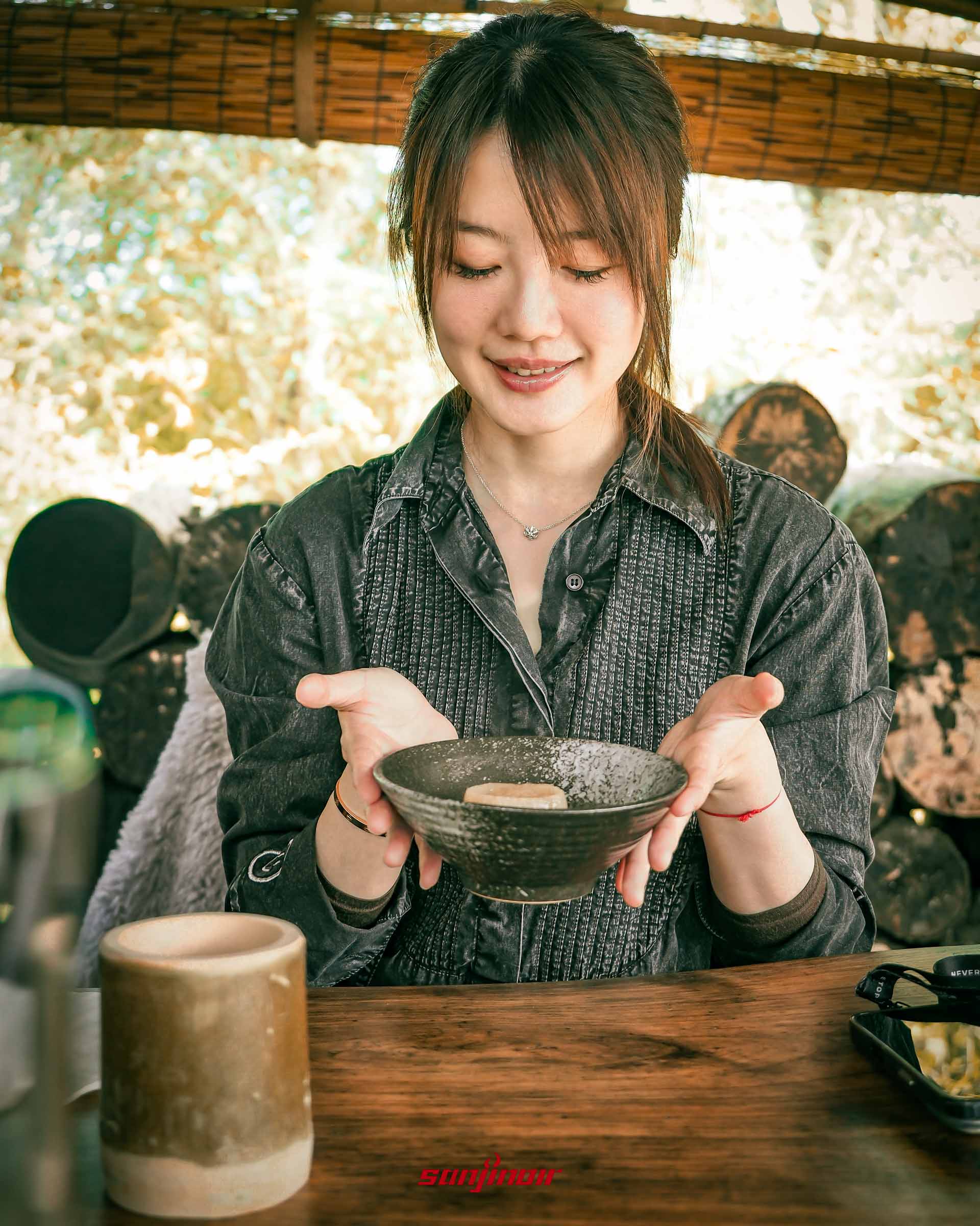 《一名空姐的流水帳日記》作者Zoe王小凡雙手捧著裝有食物黑色瓷碗露出微笑。
