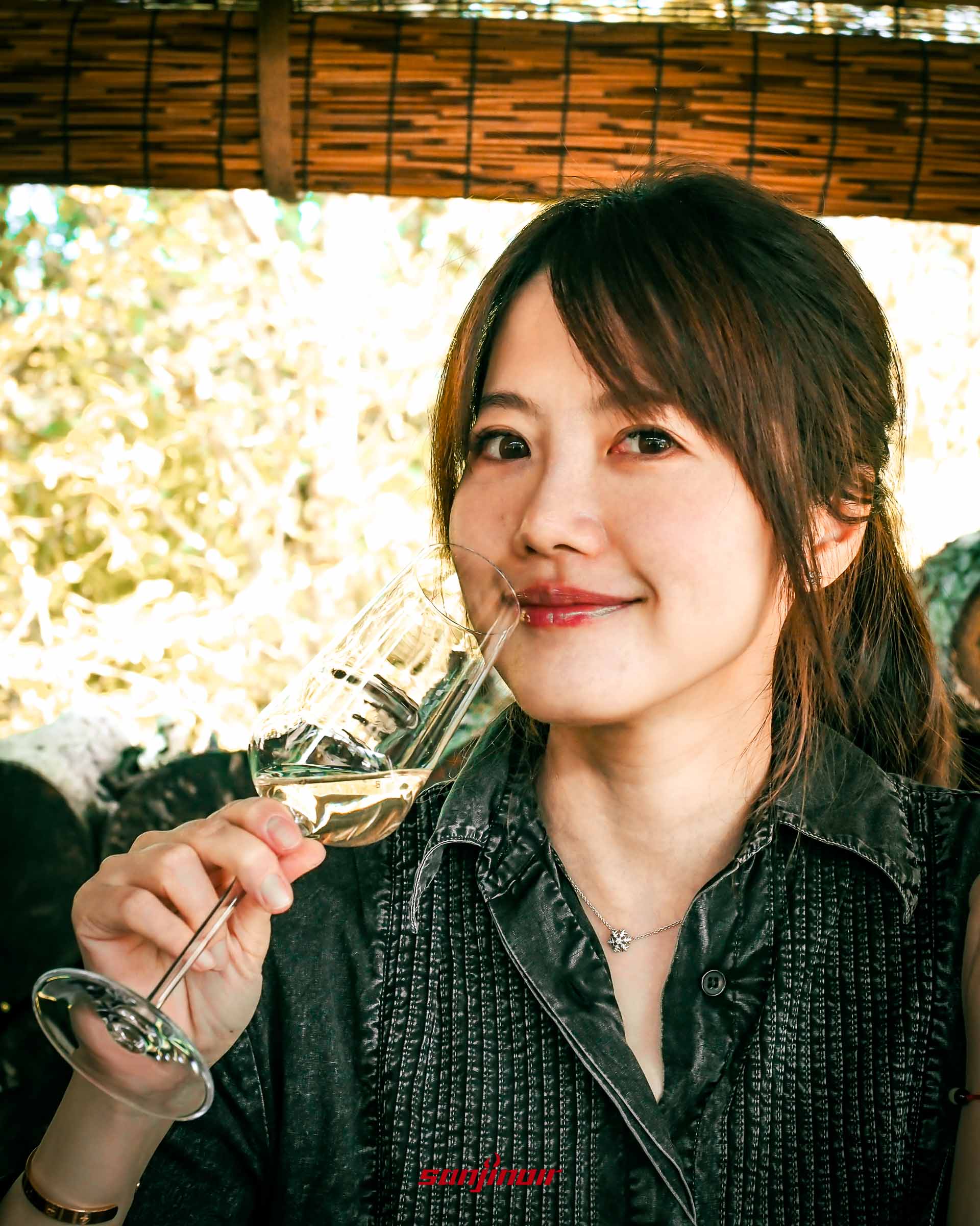 《一名空姐的流水帳日記》作者Zoe王小凡手持裝有白酒透明高腳杯看著鏡頭微笑。