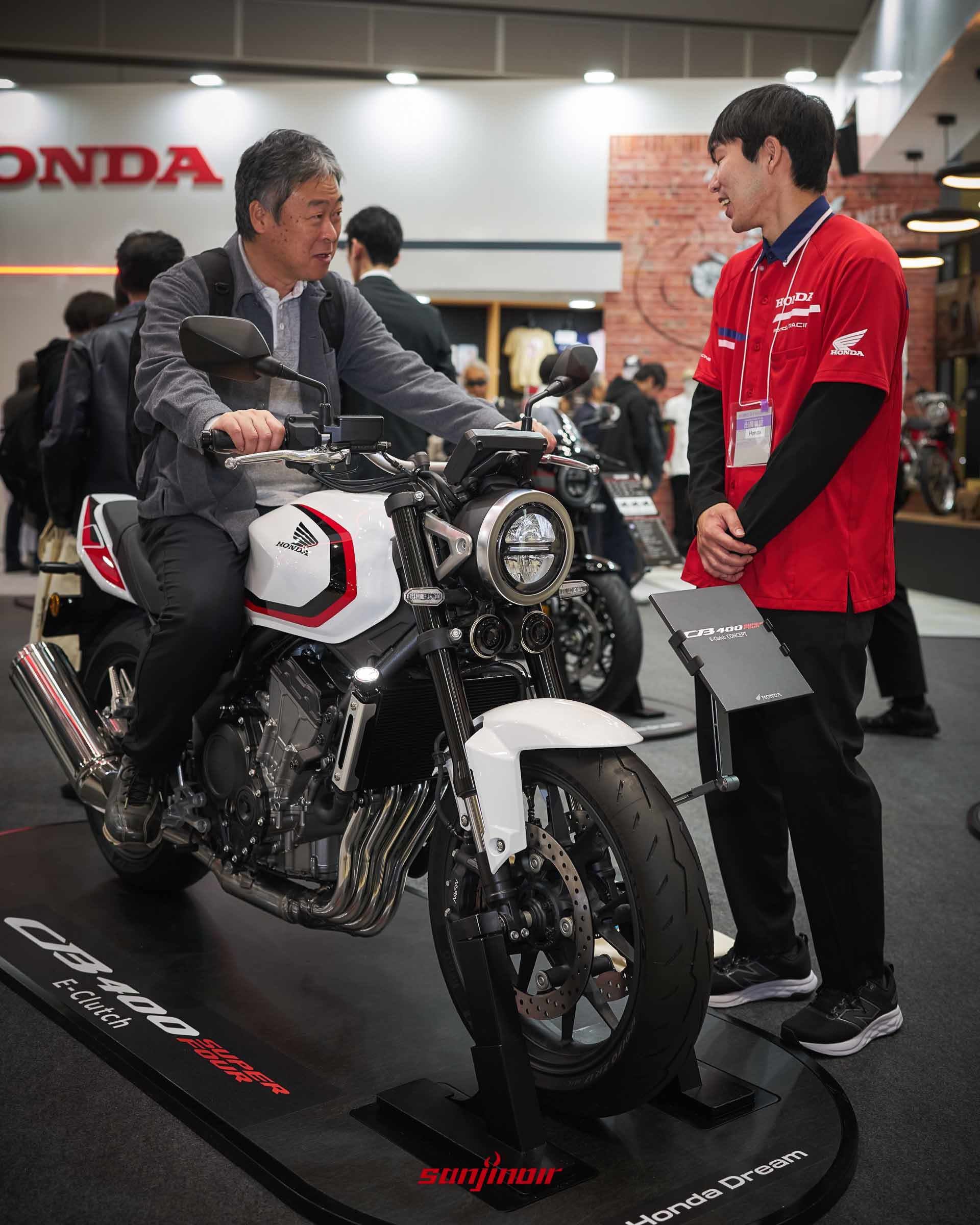 民眾於機車展試跨白紅經典塗裝的Honda CB400 Super Four並與本田工作人員交流。