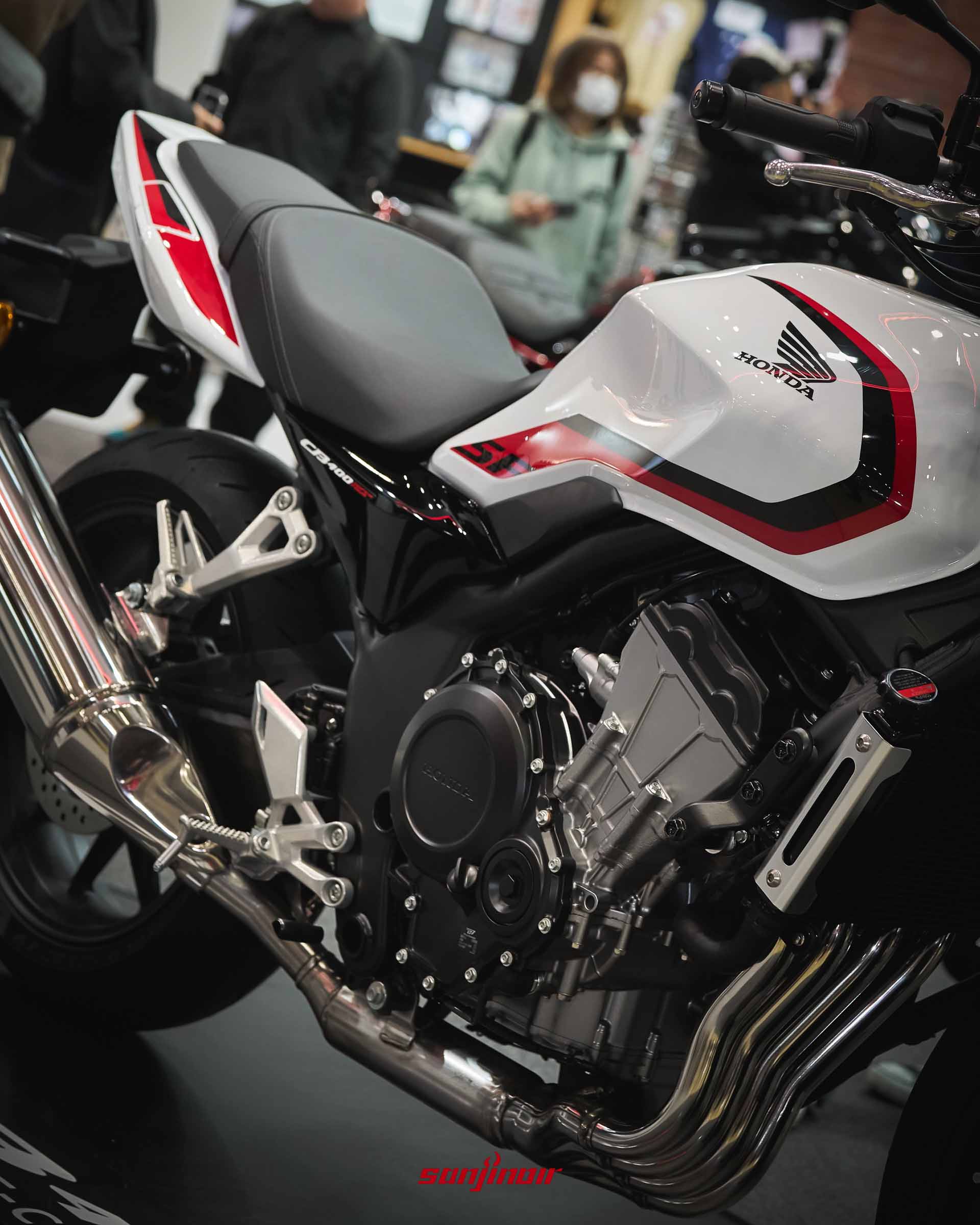 白紅塗裝的Honda CB400 Super Four側面特寫,展示油箱線條與引擎輪廓。